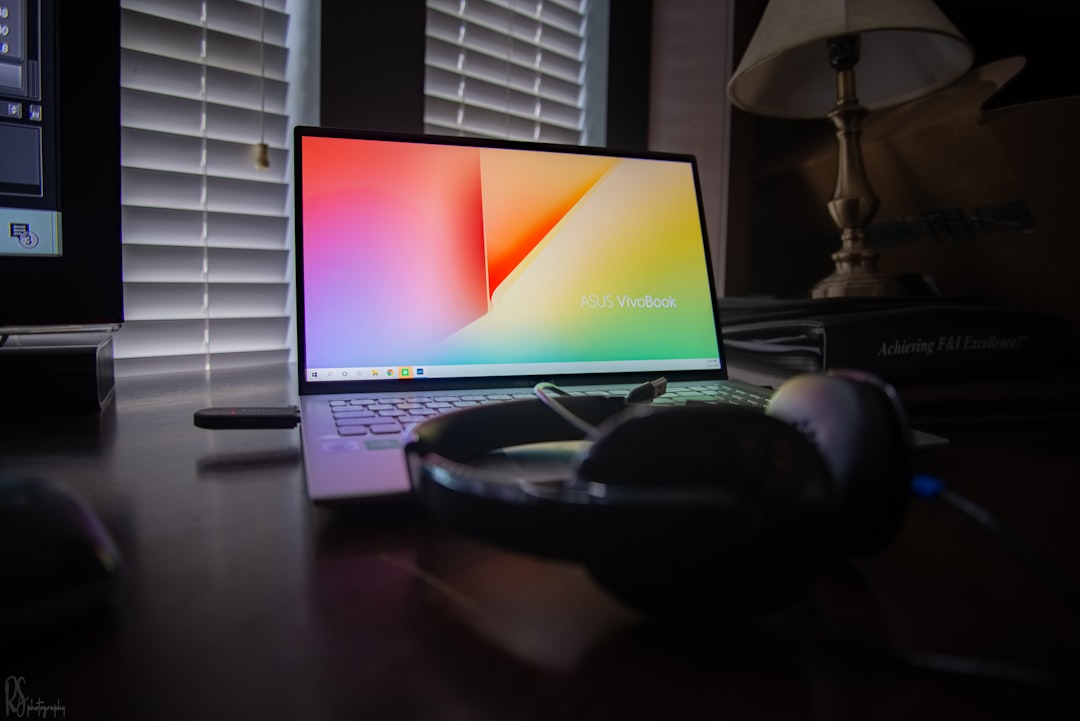 black and gray laptop computer turned on beside black headphones